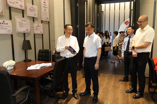 广西税务局党委委员、总经济师黄尚书（左二）和柳州职业技术大学党委书记刘子林（左一）在柳州市高校税收普法教育实践站税收普法教育研究室翻阅税法知识读本